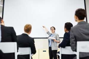 Person pointing at a whiteboard during a presentation