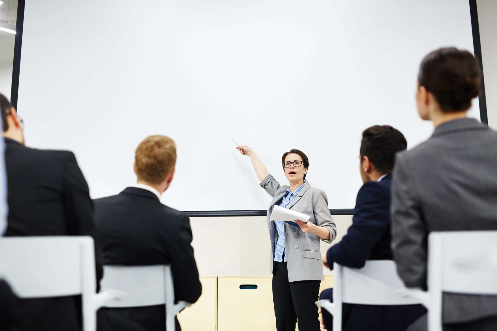 Person pointing at a whiteboard during a presentation